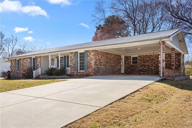 ranch-style house featuring an attached carport, driveway, brick siding, and a front lawn