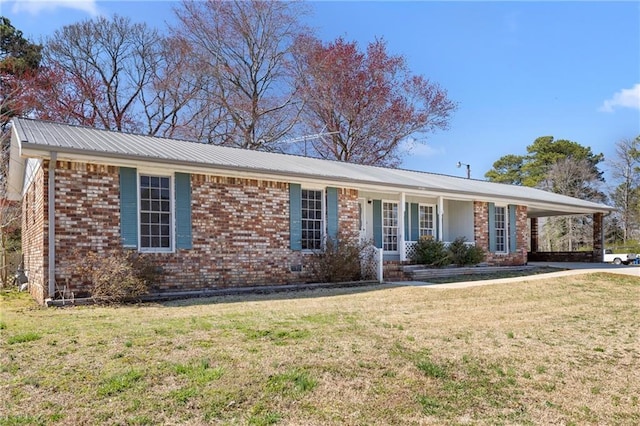 single story home with metal roof, brick siding, and a front yard