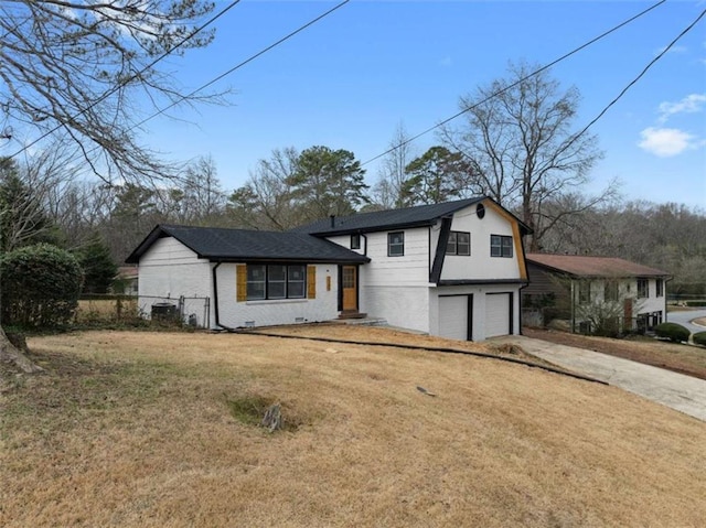 tri-level home with a garage and a front yard