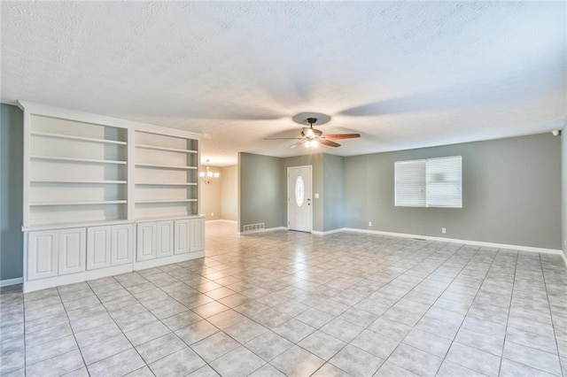 unfurnished living room featuring light tile patterned floors, a textured ceiling, built in features, and ceiling fan