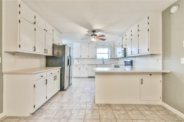 kitchen featuring ceiling fan, stainless steel appliances, white cabinets, kitchen peninsula, and light tile patterned flooring