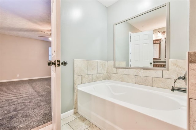 bathroom with tile patterned flooring, ceiling fan, and a tub