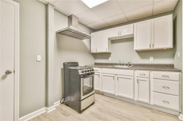 kitchen featuring ventilation hood, light hardwood / wood-style floors, white cabinets, and stainless steel range