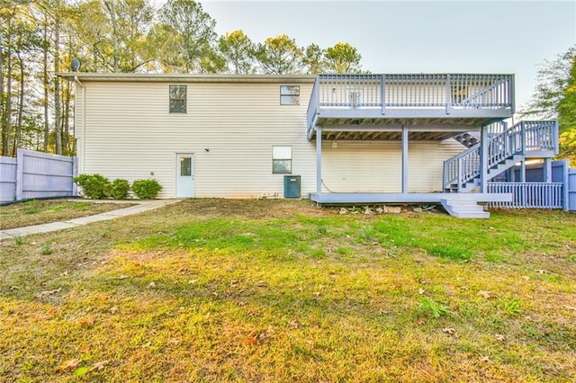 rear view of house featuring a lawn and a wooden deck