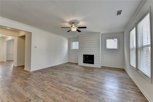 unfurnished living room featuring visible vents, a large fireplace, a ceiling fan, and wood finished floors