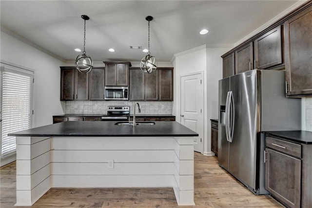 kitchen with dark countertops, dark brown cabinetry, appliances with stainless steel finishes, and a sink