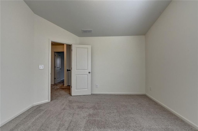 empty room with visible vents, baseboards, carpet, and lofted ceiling