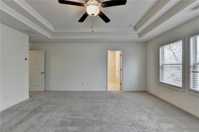 empty room with ornamental molding, baseboards, a tray ceiling, and carpet floors