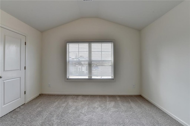 unfurnished room with baseboards, lofted ceiling, and carpet flooring