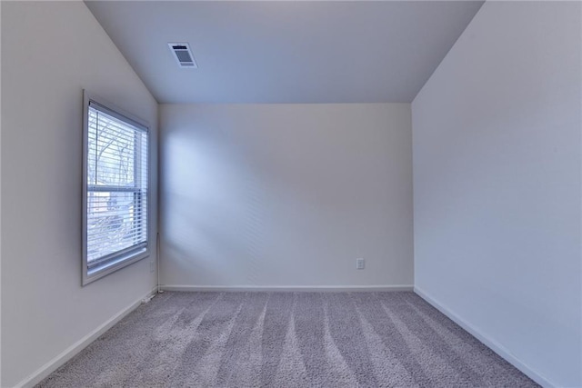 unfurnished room featuring visible vents, light carpet, baseboards, and vaulted ceiling