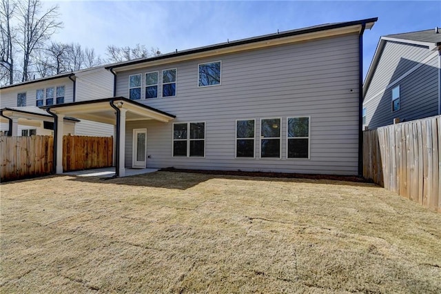 rear view of house with a yard and a fenced backyard