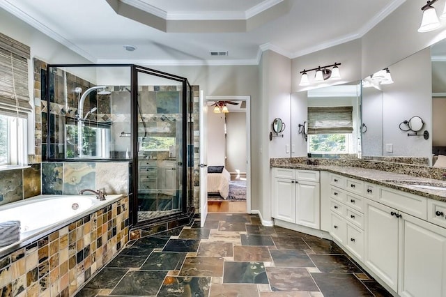 ensuite bathroom with visible vents, double vanity, a tray ceiling, a sink, and a stall shower
