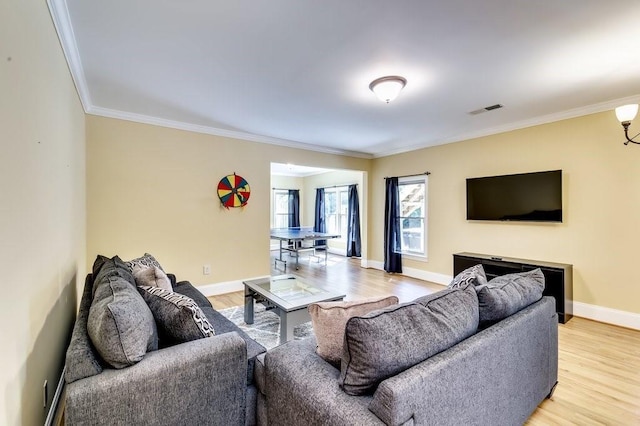 living room with visible vents, ornamental molding, baseboards, and light wood-type flooring