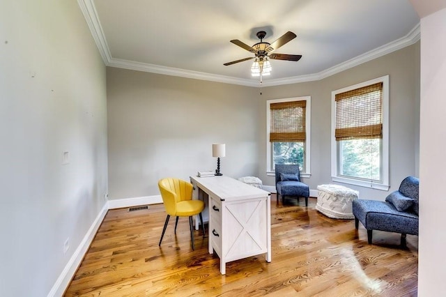 office space with crown molding, ceiling fan, light wood finished floors, baseboards, and visible vents