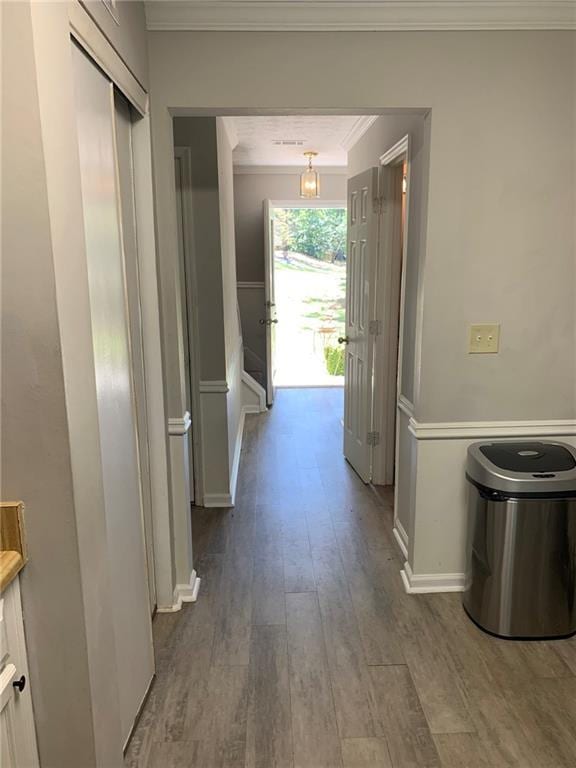 hall featuring ornamental molding, wood finished floors, and baseboards