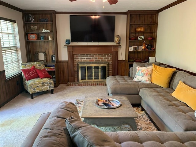 living room with a fireplace, carpet, crown molding, and wainscoting