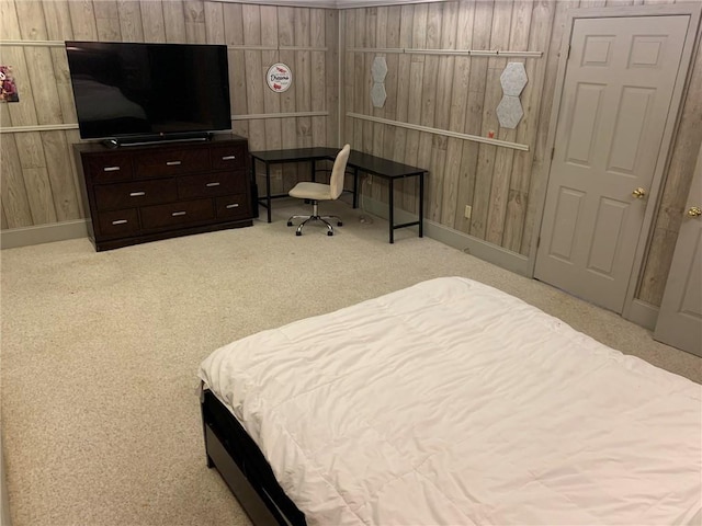 bedroom featuring baseboards, wooden walls, and carpet