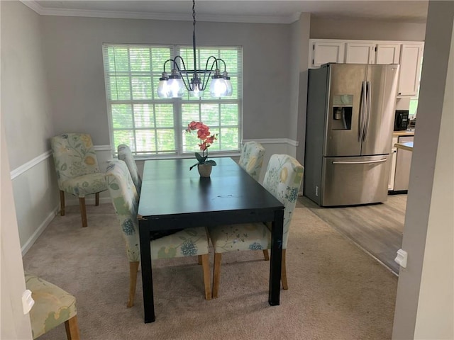 dining area with ornamental molding, light carpet, and an inviting chandelier