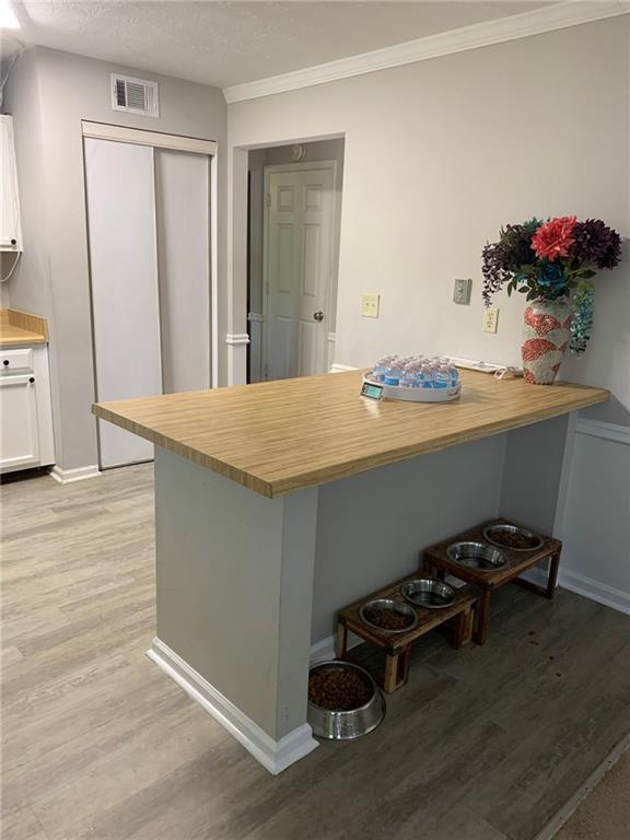 kitchen featuring visible vents, wooden counters, and light wood-style flooring