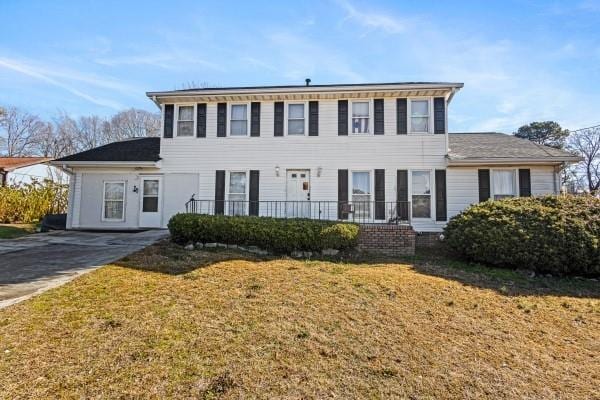 colonial inspired home featuring a front lawn