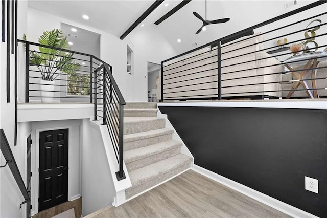 stairway with hardwood / wood-style flooring, ceiling fan, and beamed ceiling