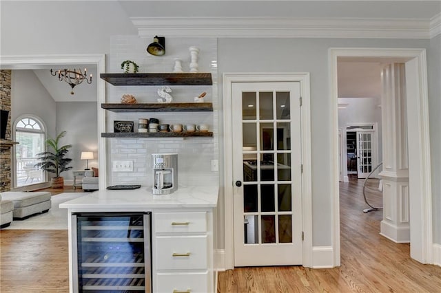 bar with vaulted ceiling, light hardwood / wood-style floors, wine cooler, light stone countertops, and white cabinets