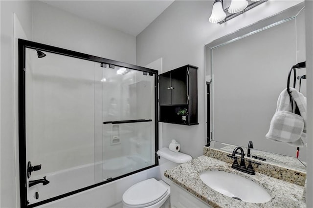 full bathroom with enclosed tub / shower combo, oversized vanity, and toilet