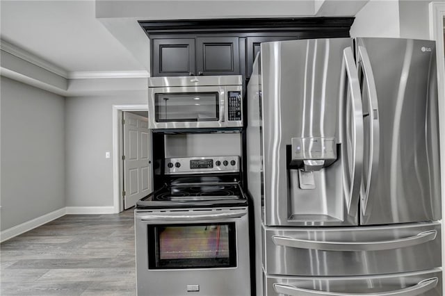 kitchen featuring stainless steel appliances, light hardwood / wood-style flooring, and ornamental molding