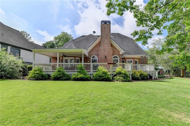 rear view of house with a wooden deck and a yard