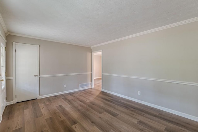 empty room with hardwood / wood-style flooring, crown molding, and a textured ceiling