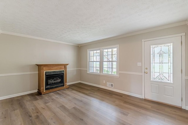 entryway featuring ornamental molding, a textured ceiling, and light wood-type flooring