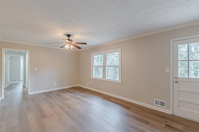 empty room with crown molding, a textured ceiling, and light hardwood / wood-style flooring