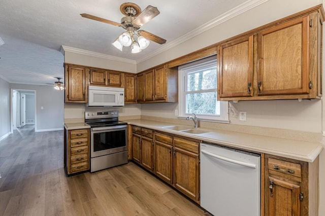 kitchen featuring sink, crown molding, light wood-type flooring, ceiling fan, and white appliances