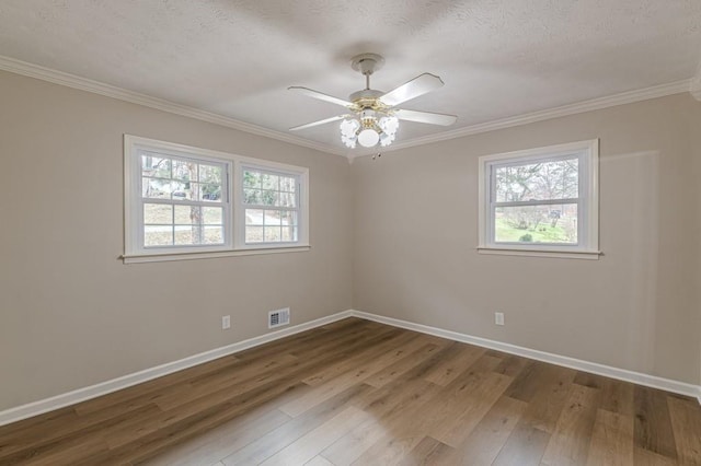 empty room with hardwood / wood-style flooring, ornamental molding, ceiling fan, and a textured ceiling
