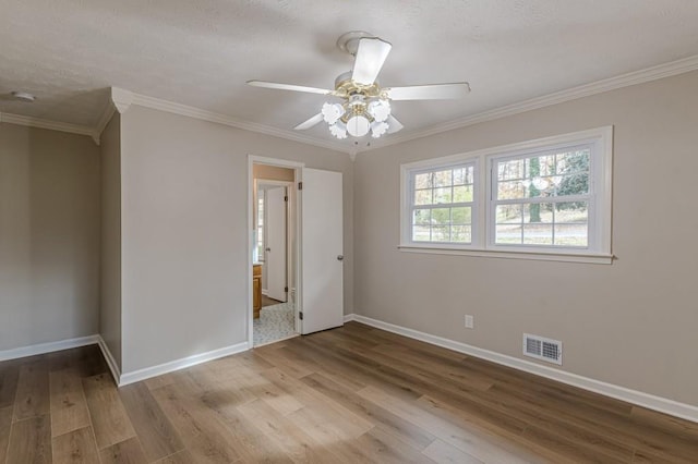 spare room with ornamental molding, ceiling fan, and light wood-type flooring