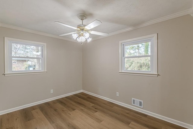 empty room with ceiling fan, crown molding, a wealth of natural light, and light hardwood / wood-style floors