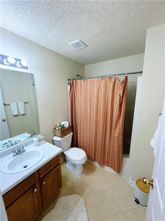 7104 Georges Way, Morrow, GA 30260 - full bath with tile patterned floors, vanity, a textured ceiling, and shower / bath combination with curtain