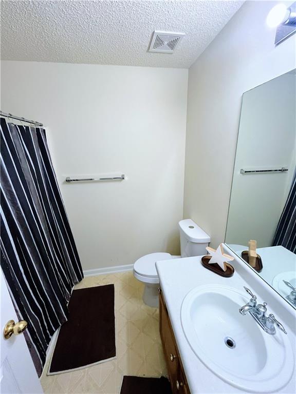 7104 Georges Way, Morrow, GA 30260 - bathroom featuring a textured ceiling, vanity, and a shower with shower curtain