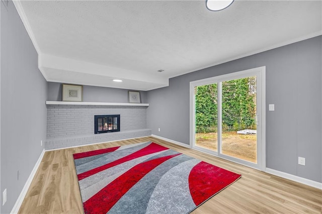 living room with ornamental molding, hardwood / wood-style floors, and a brick fireplace