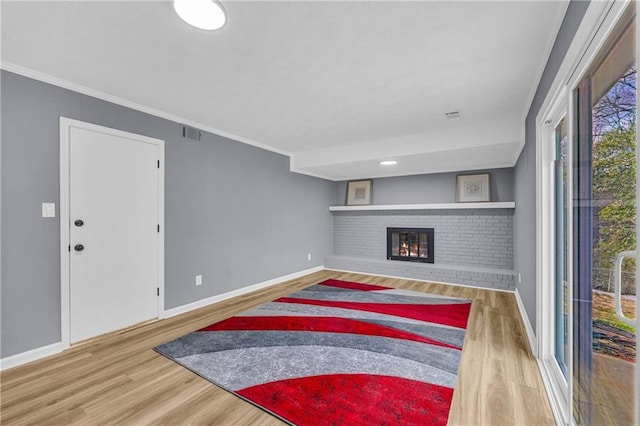 living room featuring hardwood / wood-style flooring, ornamental molding, and a fireplace