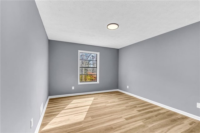 unfurnished room featuring a textured ceiling and light hardwood / wood-style floors