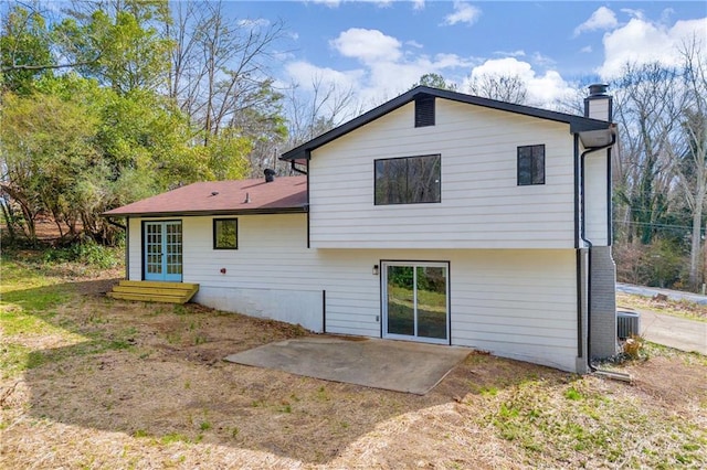 rear view of property featuring central AC unit and a patio area