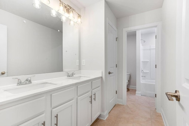full bath with toilet, tile patterned floors, double vanity, and a sink