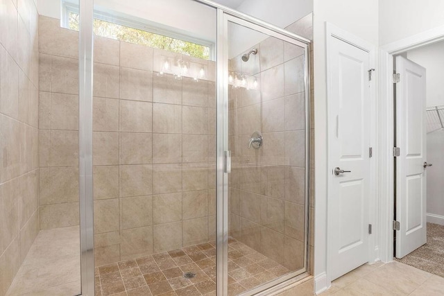full bath featuring a shower stall, tile patterned floors, and a closet