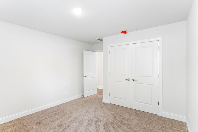 unfurnished bedroom featuring carpet, a closet, visible vents, baseboards, and recessed lighting