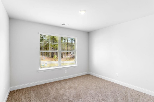 carpeted spare room featuring baseboards