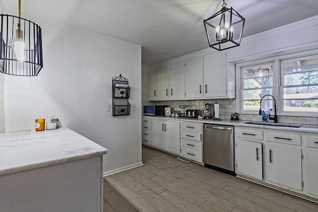 kitchen with light wood finished floors, a sink, backsplash, stainless steel appliances, and light countertops