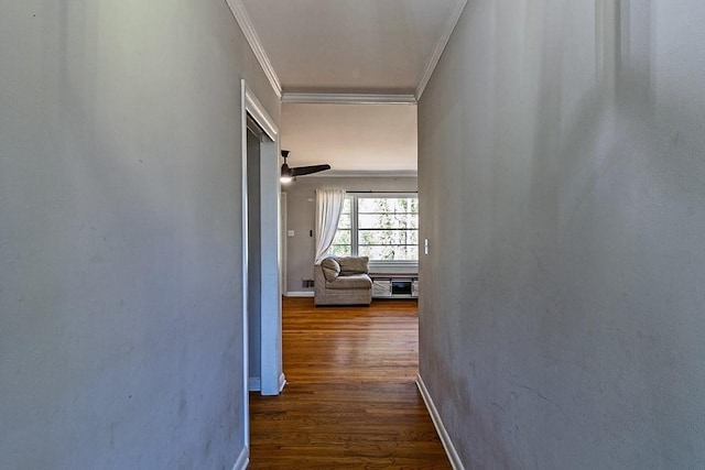 hall featuring dark wood finished floors, baseboards, and ornamental molding