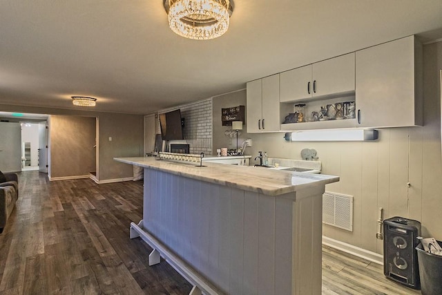 kitchen featuring visible vents, dark wood finished floors, open shelves, a peninsula, and white cabinets