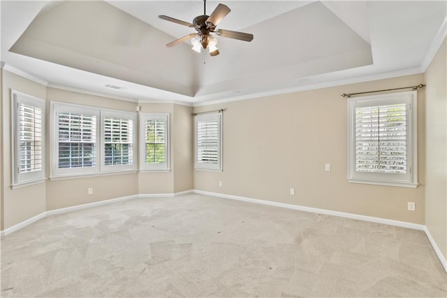empty room featuring carpet flooring, a tray ceiling, crown molding, and ceiling fan